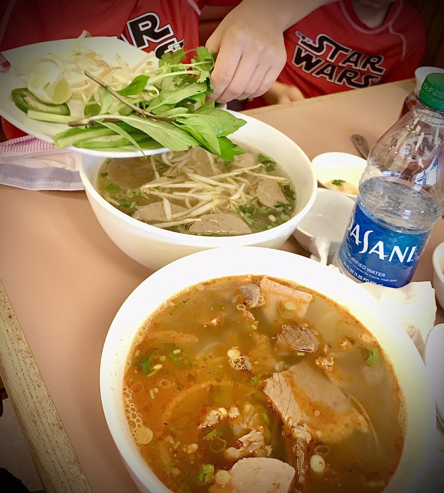 A steaming bowl of spicy beef noodle soup at Pho Happy Wok